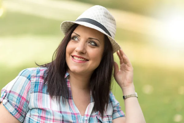 Ritratto di bella giovane donna con cappello in parco, effetto luce — Foto Stock