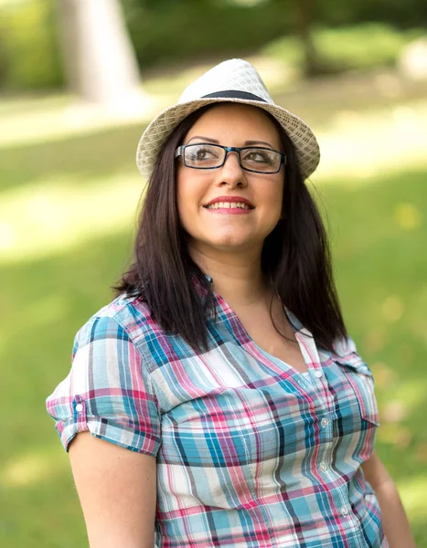 Ritratto di bella giovane donna con cappello in parco — Foto Stock