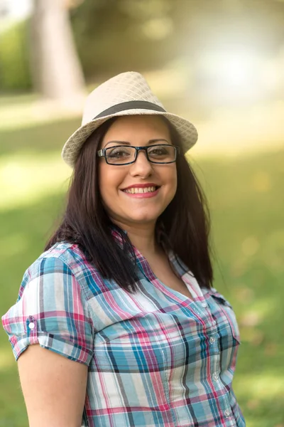 Ritratto di bella giovane donna con cappello in parco, effetto luce — Foto Stock