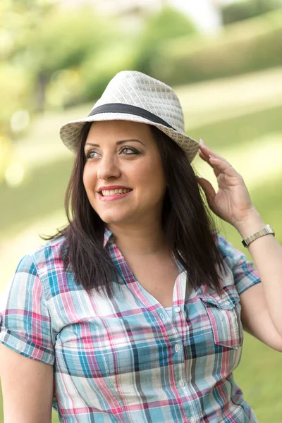 Ritratto di bella giovane donna con cappello in parco — Foto Stock