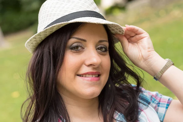 Portrait of beautiful young woman with hat in park, light effect — Stock Photo, Image