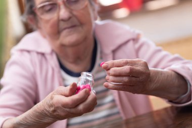 Yaşlı kadın ilacını alıyor.