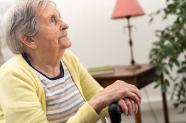 Elleri bastonda yaşlı bir kadın.