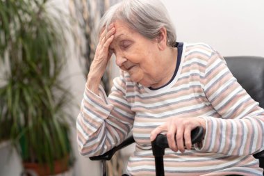 Yaşlı kadın baş ağrısı çekiyor.