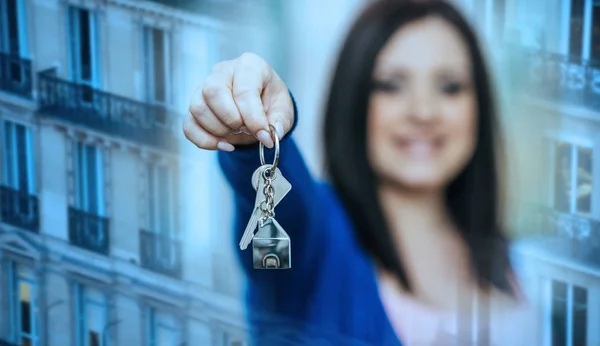 Frau hält Hausschlüssel hoch; Mehrfachbelichtung — Stockfoto