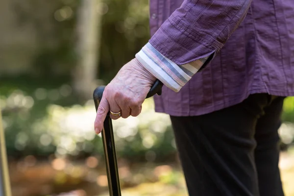 Oudere vrouw met een wandelstok — Stockfoto