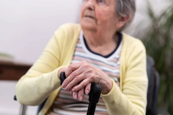 Vieja con las manos en un bastón — Foto de Stock