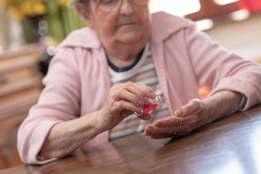 Yaşlı kadın ilacını alıyor.