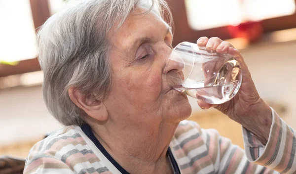 Ηλικιωμένη γυναίκα πόσιμου νερού — Φωτογραφία Αρχείου