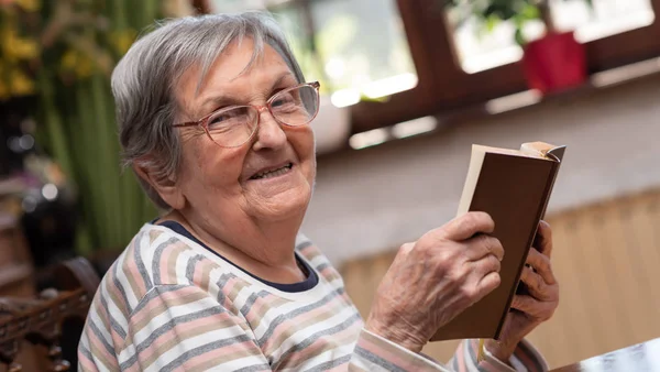 Staruszka czytająca książkę — Zdjęcie stockowe