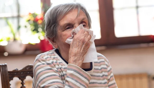 Old woman blowing her nose — ストック写真