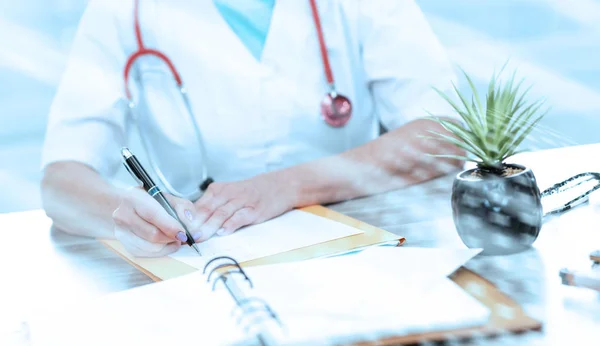 Médico femenino que escribe una receta médica; efecto ligero — Foto de Stock