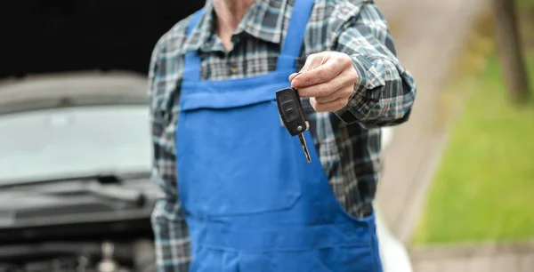 Mechanic delivering car keys after car engine checking — Stock Photo, Image