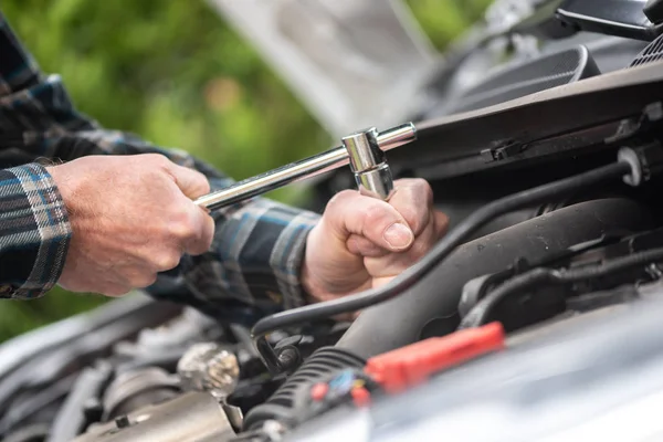 Manos del mecánico del coche que trabaja en el motor del coche — Foto de Stock