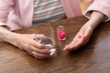 Yaşlı kadın ilacını alıyor.