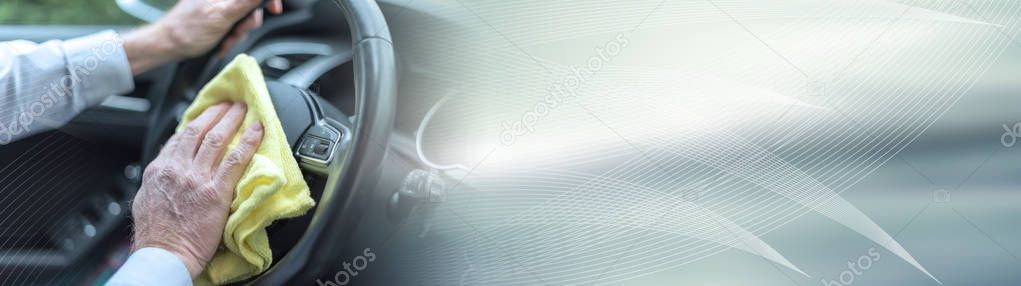 Man cleaning a car steering wheel; panoramic banner