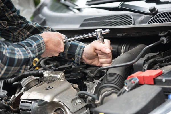 Manos del mecánico del coche que trabaja en el motor del coche — Foto de Stock