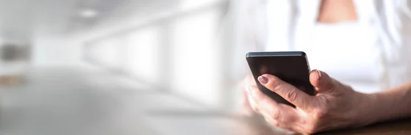 Las manos de la mujer usando un teléfono móvil; banner panorámico — Foto de Stock