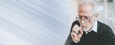 Elektronik sigara içen yaşlı bir adamın portresi; panoramik pankart