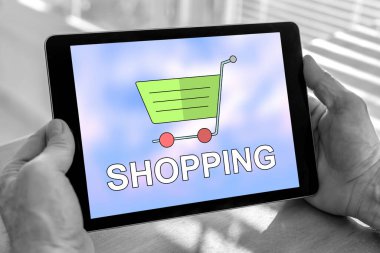 Erkek eli, alışveriş konsepti olan bir tablet tutuyor.