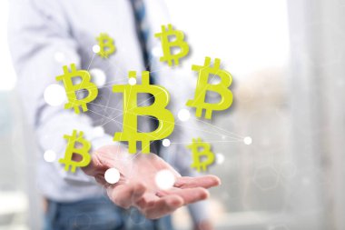 Bitcoin kavramı arka plandaki bir adamın elinin üstünde.