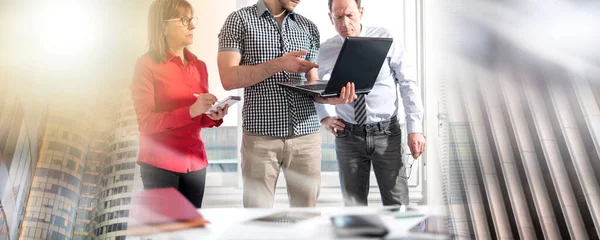 Business people in meeting working on laptop in office; multiple exposure