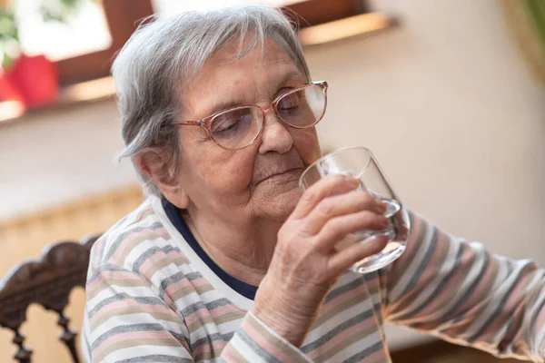 Ηλικιωμένη Γυναίκα Που Κρατάει Ένα Ποτήρι Νερό Στο Σπίτι — Φωτογραφία Αρχείου