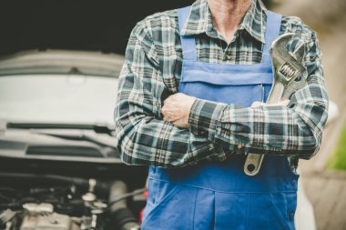 Kolları çapraz araba tamircisi.