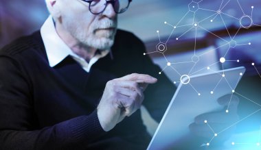 Yaşlı adam tabletini evde kullanıyor, ışık efekti.