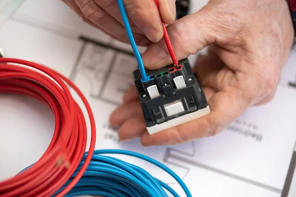 将电线连接到电源插座的电工手 — 图库照片
