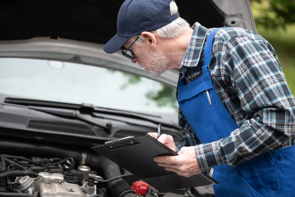 Car Mechanic Checking Car Engine Writing Clipboard — Stock Photo, Image