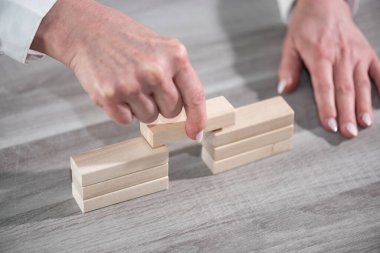 Kadın el yapımı ahşap bloklu bir köprü; ortaklık kavramı