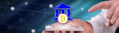 Bitcoin düzenleme kavramı, bir adamın elinde tuttuğu akıllı telefonun üstünde.