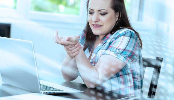 Молодая деловая женщина, страдающая от боли в запястье; легкий эффект
