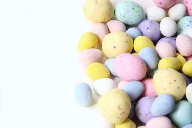 Pastel şeker yumurta, çikolata ile dolu beyaz bir arka plan üzerinde kopya alanı izole.