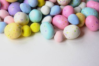 Pastel şeker yumurta, çikolata ile dolu beyaz bir arka plan üzerinde kopya alanı izole.