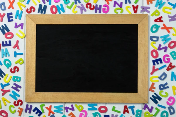 Bunte englische Buchstaben und Tafel auf weißem Holzhintergrund — Stockfoto