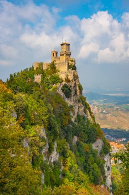 İtalya, San Marino 'daki Guaita kulesi parlak yaz güneşi, mavi gökyüzü ve bulutlarla aydınlanır..