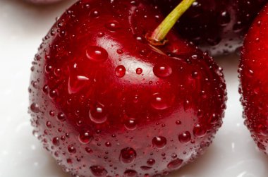 Sudaki parlak kiraz damlaları masaya yakın duruyor.