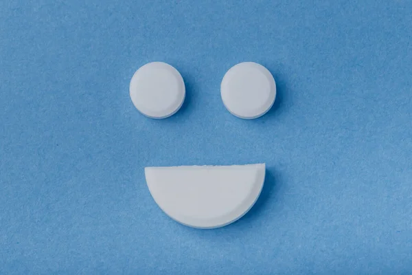 Sonrisa de píldoras sobre fondo azul —  Fotos de Stock
