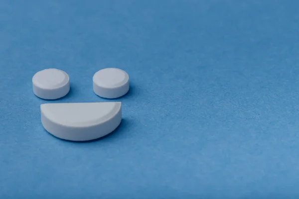 Mosoly tabletták felett kék háttér Jogdíjmentes Stock Képek