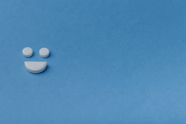 Mosoly tabletták felett kék háttér Stock Kép