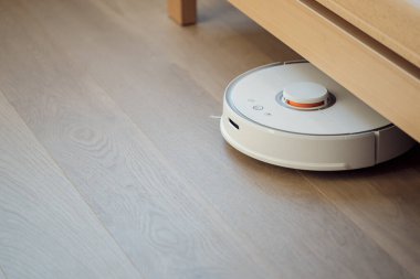 Robot elektrikli süpürge, akıllı dairenin otomatik temizliğini yapıyor.