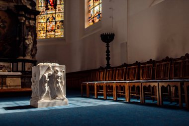 Mihrabın üzerinde ve kilisenin zemininde hafif lekeler var. Güneş ışığı vitrinden süzülmüş. Işık ve gölge oyunu. Yıllanmış bir fotoğraf. Sepya.