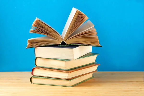 Ein Stapel Bücher auf dem Tisch vor blauem Hintergrund. — Stockfoto