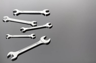 Gri bir arka planda anahtarlar. Ayna yüzeyi. Bir düzlemde görüntüle. Boşluğu kopyala.