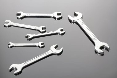 Gri bir arka planda anahtarlar. Ayna yüzeyi. Bir düzlemde görüntüle. Boşluğu kopyala.