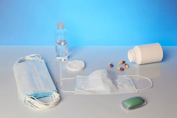 Pencegahan dari pencegahan epidemi penyakit virus. Bar sabun, alkohol dan masker medis dengan latar belakang biru — Stok Foto
