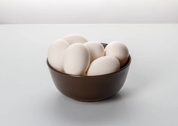 Huevos de pollo blancos en un plato sobre un fondo blanco . — Foto de Stock