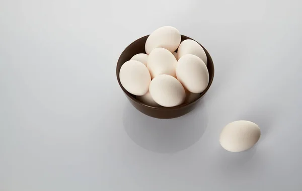 Huevos de pollo blancos en un plato sobre un fondo blanco. Vista desde arriba . — Foto de Stock